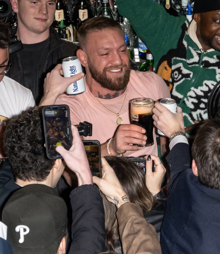 Conor McGregor serves up a pint to fans while making a surprise appearance at Ladder 15 in Philadelphia.