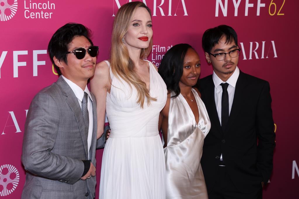 Angelina Jolie, in a white dress, with Zahara Jolie, in a cream silk dress, Maddox Jolie, in a grey suit and Pax Jolie in a black suit.
