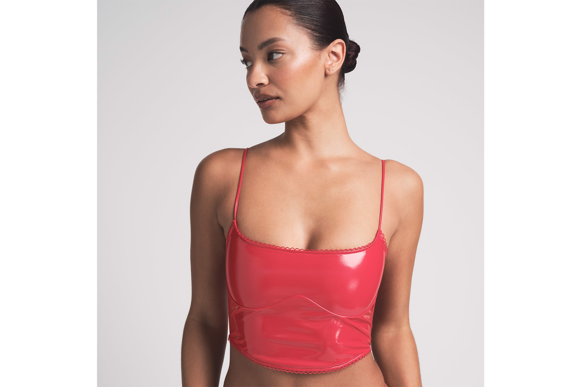 A model in a red vinyl corset