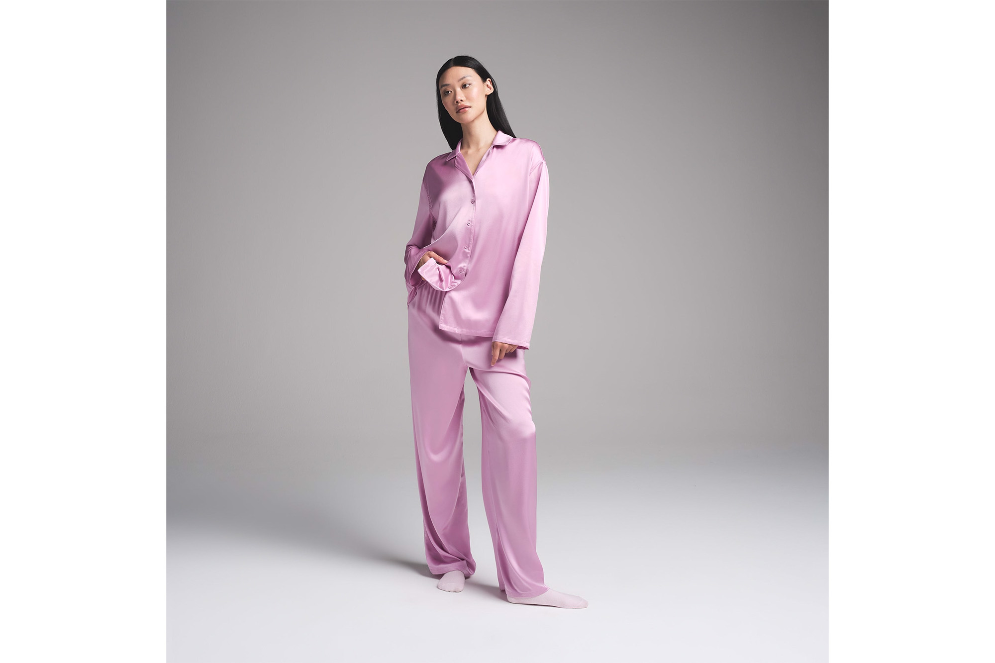A model in pink silk pajamas