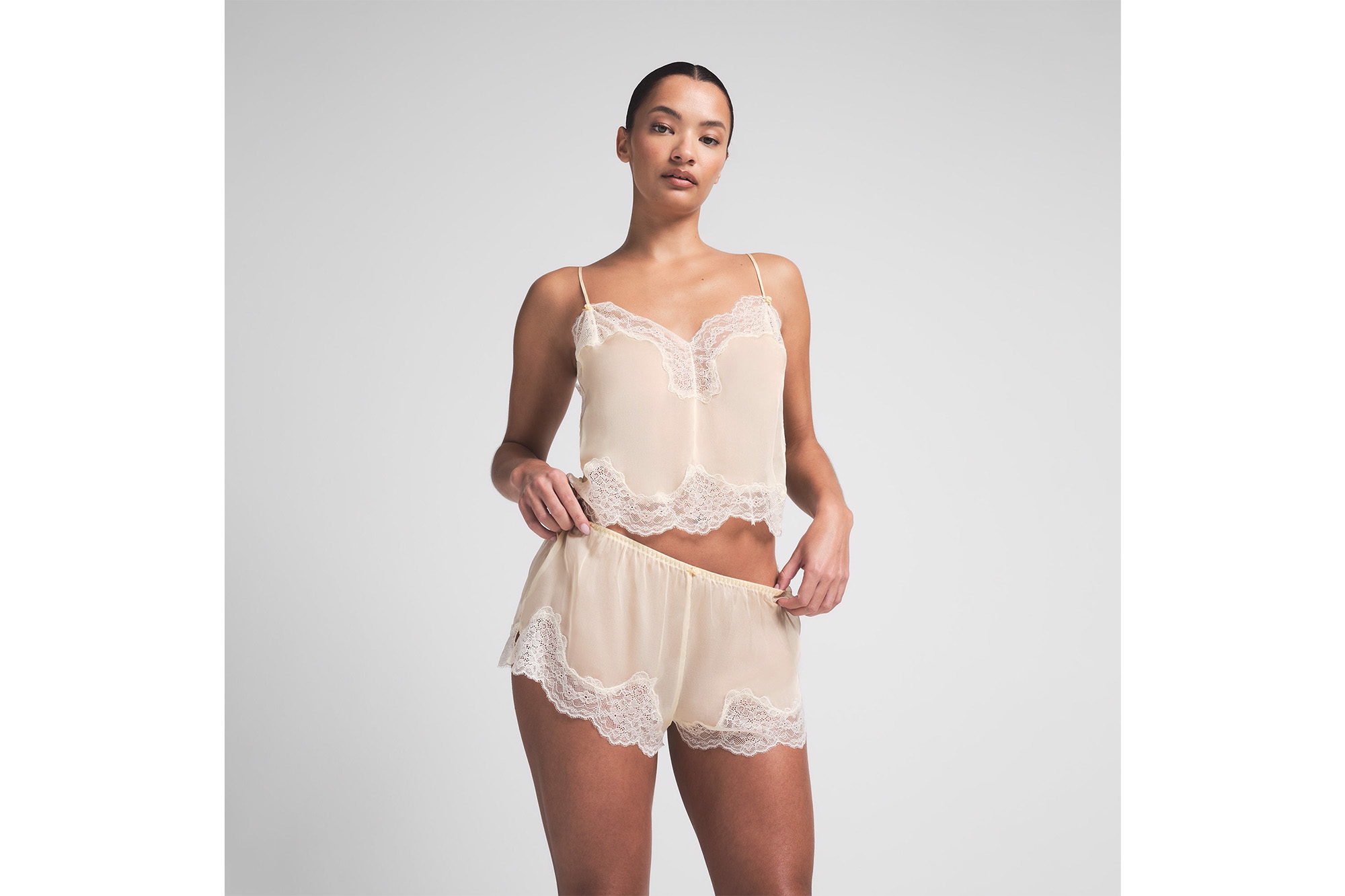 A model in a lace cami and shirts